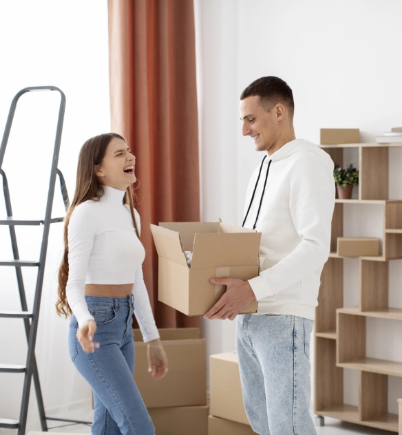 Couple holding moving boxes